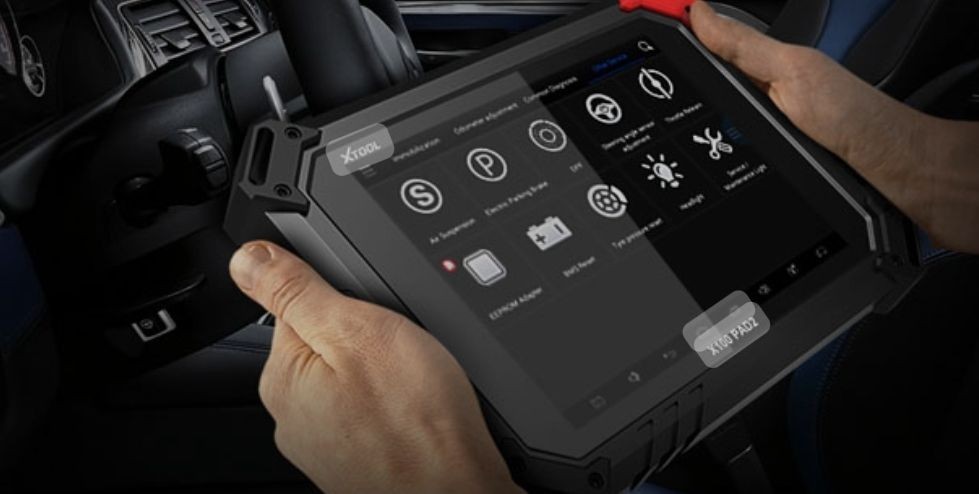 Person holding a diagnostic tablet inside a car, displaying automotive system check options on the screen.